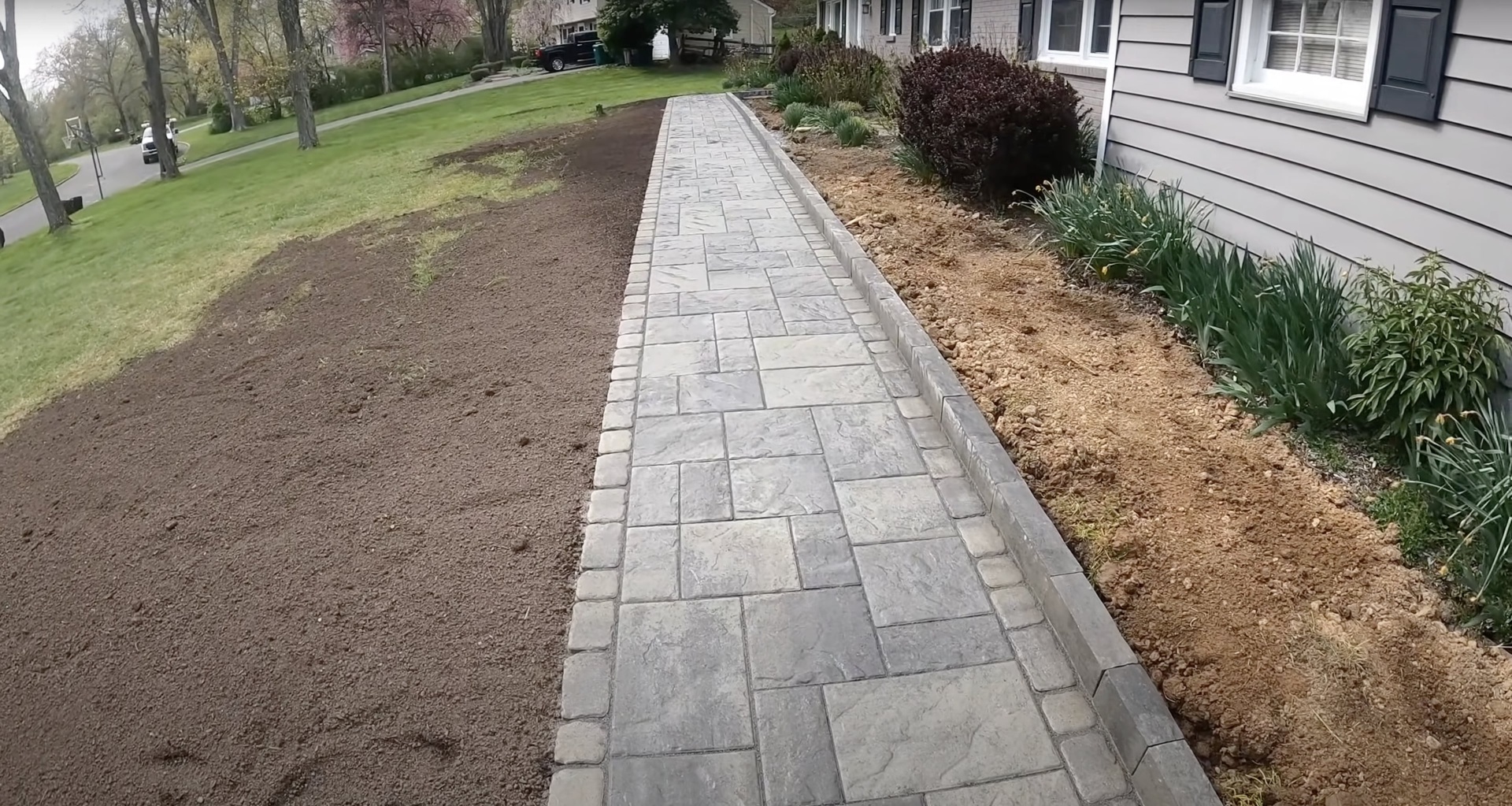 Beautiful stamped concrete walkway with decorative pattern in residential setting