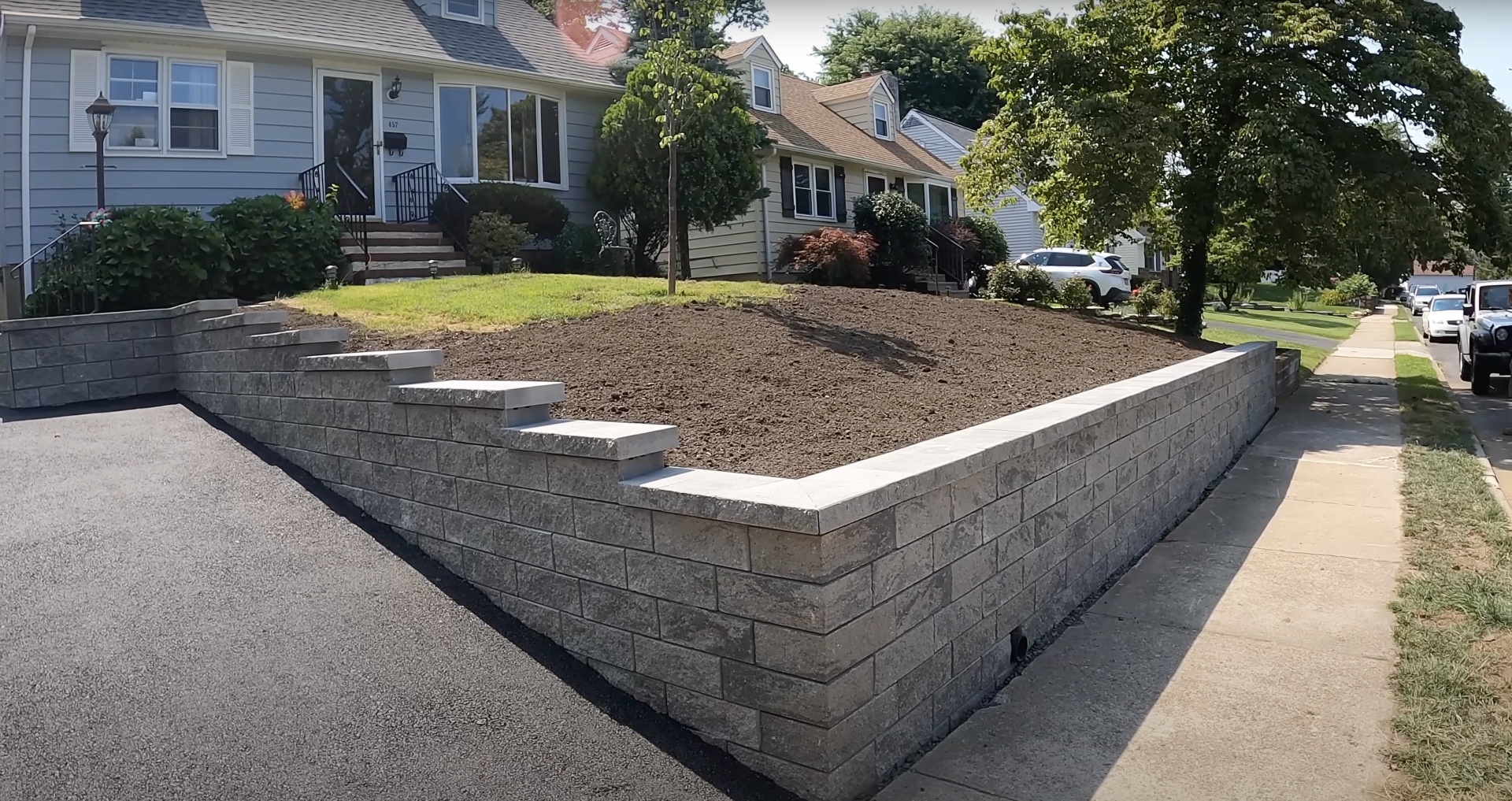 Professional concrete retaining wall construction with precise block placement in residential Burien neighborhood
