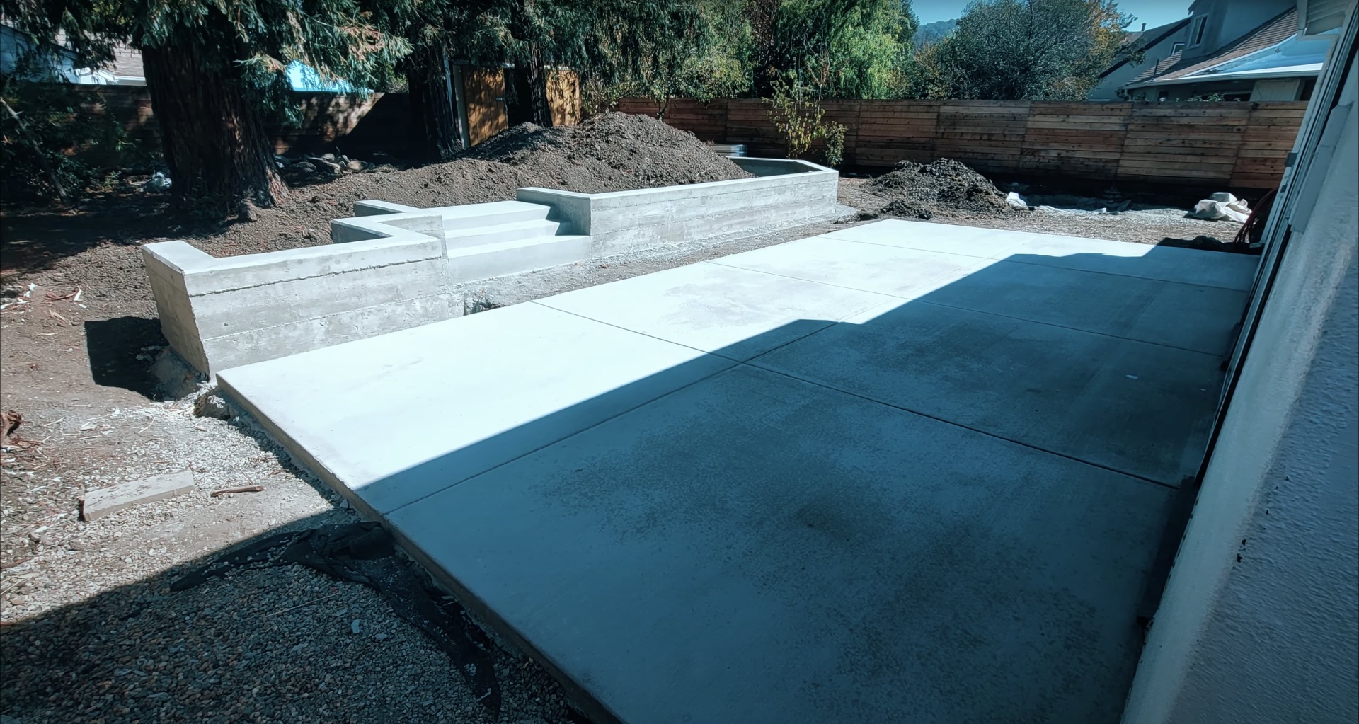 Modern concrete patio and retaining wall system creating multi-level outdoor living space