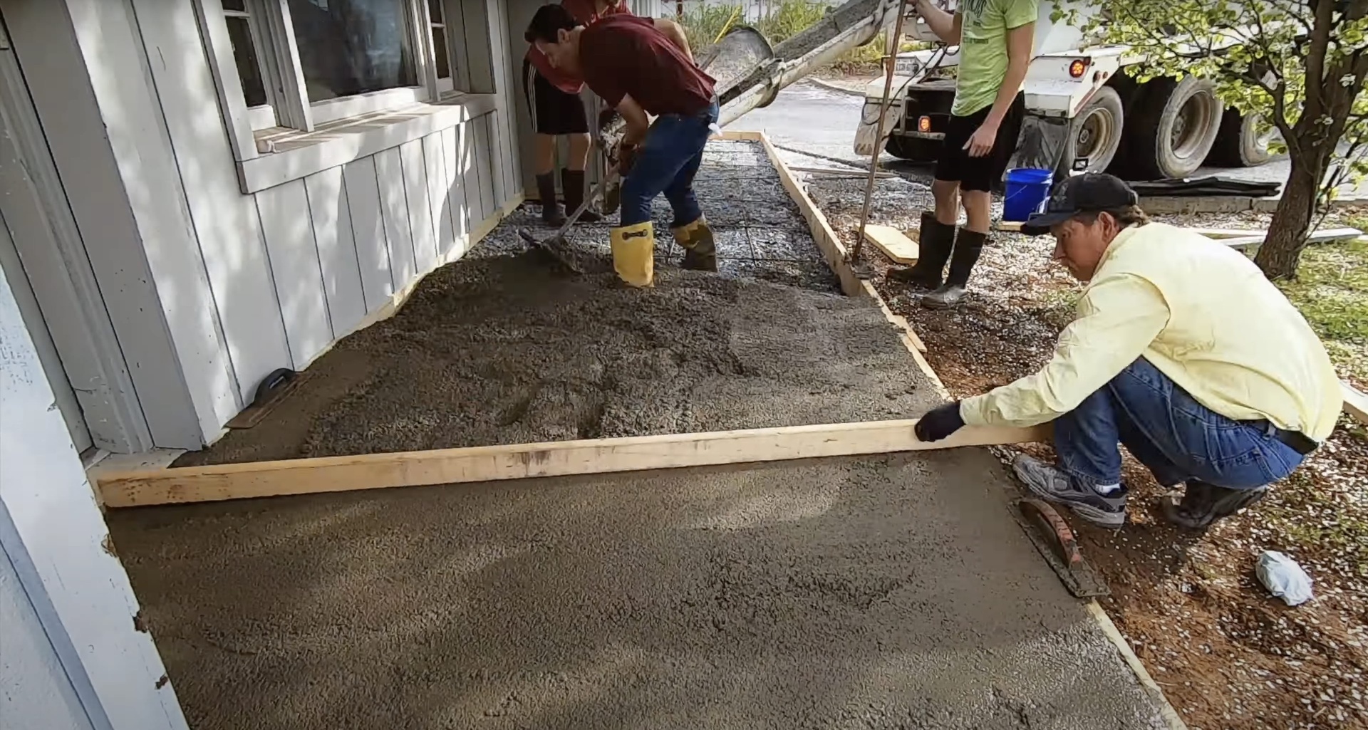 Concrete crew pouring fresh concrete for residential driveway construction in Burien